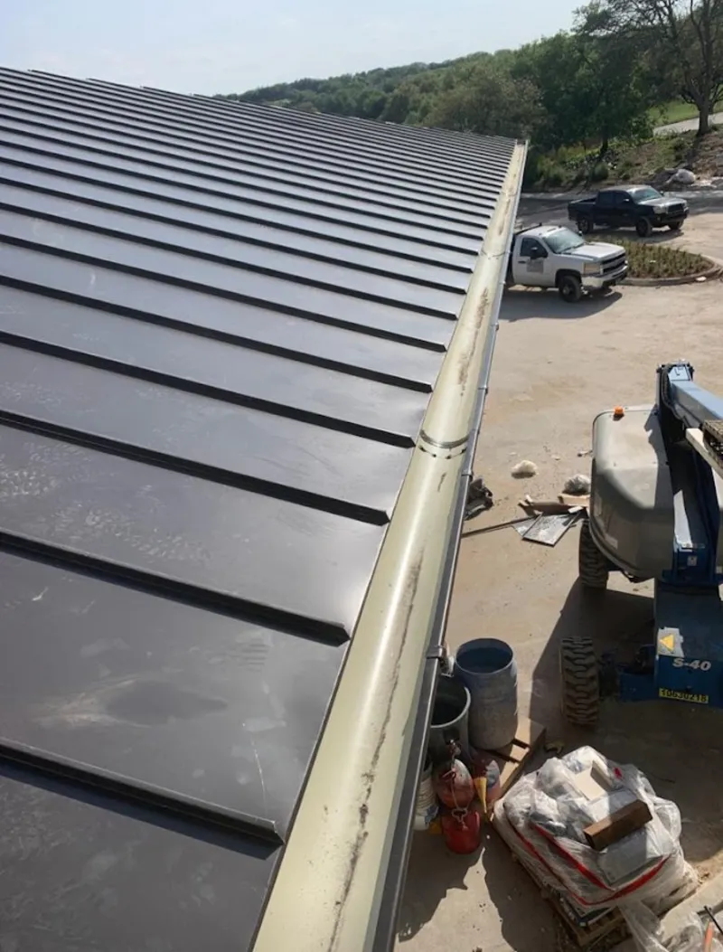 Standing seam panel and gutter detail on a metal roofing jobsite in Alma